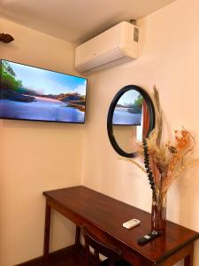 a room with a table and a tv on the wall at Casa Esmeralda Boutique Hotel in San José