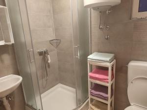 a bathroom with a shower and a toilet and a sink at Nives apartmani in Pakoštane +63 photos