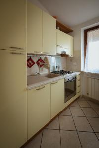 a kitchen with white cabinets and a sink at Orli Home e Relax in Casole dʼElsa
