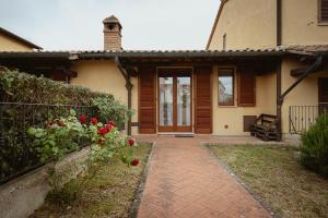 a house with a brick walkway leading to the front door at Orli Home e Relax in Casole dʼElsa