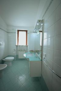 a bathroom with two sinks and a toilet and a mirror at Orli Home e Relax in Casole dʼElsa +10 photos