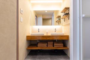 a bathroom with two sinks and a mirror at ホテル雅々音 in Sasebo