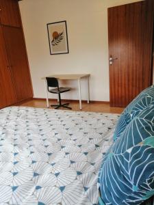 a bedroom with a bed and a table and a chair at La Doudou Maison à louer in Mons +3 photos