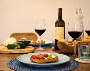 a table with two glasses of wine and a plate of food at LIGEA APARTMENT - Bright Mediterranean Home with Bali-Inspired Touches - Central Anzio near Sea, Train and Bus Station in Anzio