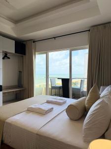 a bedroom with a white bed with a view of the ocean at Ocean Breeze Residencies in Negombo
