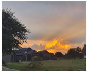 a sunset over a field with houses in the foreground at Sunset View Vaal De Grace in Grooteiland
