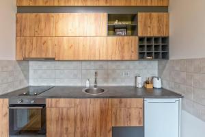 a kitchen with a sink and wooden cabinets at Vila Katalina Spa & Resort in Zlatibor