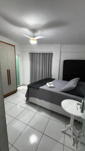 a bedroom with a bed and a table in it at Ed Odilon Vieira 104 in Vitória da Conquista
