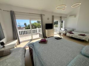 a bedroom with two beds and a television and a balcony at Marbella Villa 16 Persons -Pool in Marbella +32 photos