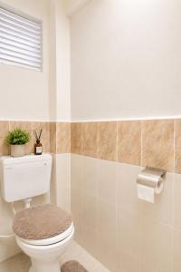 a bathroom with a white toilet and a window at Stylish 2BR Apartment Free WiFi Near Nairobi National Park in Ongata Rongai  +19 photos