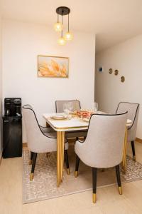 a dining room with a table and chairs at Stylish 2BR Apartment Free WiFi Near Nairobi National Park in Ongata Rongai 