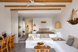 a living room with a white couch and a bed at Beach Suite Syrma in Pachaina