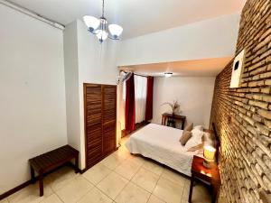 a bedroom with a bed and a brick wall at Casa Esmeralda Boutique Hotel in San José +71 photos