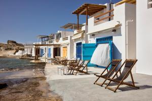 a group of chairs and tables on the side of a building at Beach Suite Syrma in Pachaina