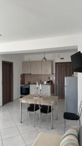 a kitchen with a table and chairs in a kitchen at Niko's apartments 2 in Elafonisos +3 photos