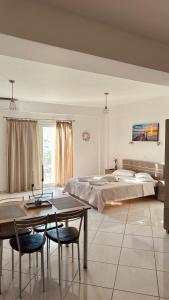 a bedroom with a bed and a table and chairs at Niko's apartments 2 in Elafonisos