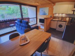 a living room with a dining table and a kitchen at Whitebearlodge in Arâches-la-Frasse
