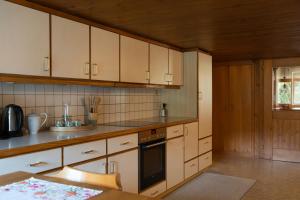 a kitchen with white cabinets and a black oven at Berghaus Antonia in Mellau