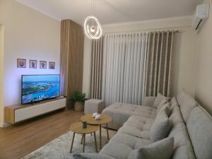 a living room with a couch and a tv at E&O Apartment in Pogradec