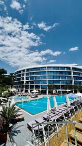 a hotel with a pool and lounge chairs and a building at Apart Maristella sea view in Odesa