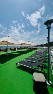 a row of lounge chairs and umbrellas on a beach at Apart Maristella sea view in Odesa