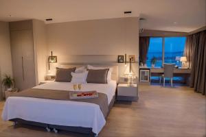 a bedroom with a large white bed and a desk at Kalyon Cesme in Çeşme