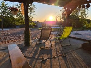 a group of chairs sitting under a gazebo with the sunset at B&b A&J in Somogyjád