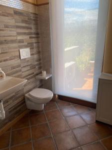a bathroom with a toilet and a sink and a window at Da Nenna Bilocale indipendente in Pescantina