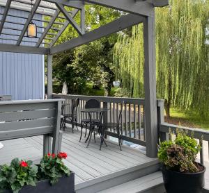 a pergola with chairs and tables on a deck at Hotel Laurance in Luray