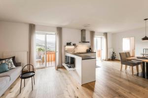 a kitchen and living room with a couch and a table at WEINBERG APARTMENTS & Brixen Südtirol Guest Pass in Natz-Schabs