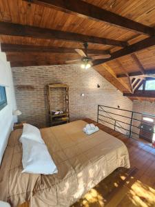 a bedroom with a large bed with a ceiling fan at Atardecer Serrano in Villa General Belgrano