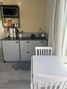 a kitchen with a white counter and a microwave at Tiny house with lake view in Hammarö