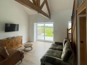a living room with a couch and a tv at Storws Tanrallt in Holyhead