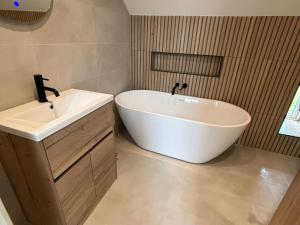a bathroom with a white tub and a sink at Storws Tanrallt in Holyhead +12 photos