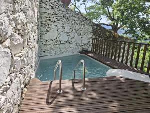 a plunge pool in a stone wall with a wooden deck at Quinta do Valdalágea in Peso da Régua