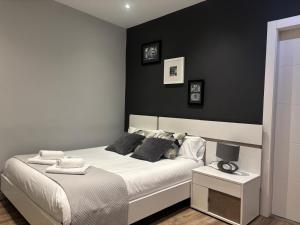 a bedroom with a white bed with a black wall at maitagarri casco antiguo in Pamplona