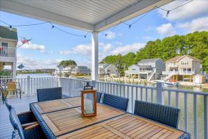 a table and chairs on a deck with a view of the water at Coastal Crab in Greenbackville