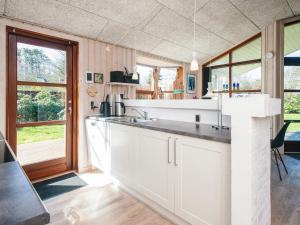 a kitchen with white cabinets and a large window at 4 star holiday home in Ulfborg in Ulfborg