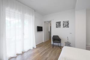 a bedroom with a bed and a chair and a window at el Zhìgol B&B in Farra di Soligo