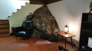 a living room with a chair and a table at Moinho da Cruz in Ponte de Lima