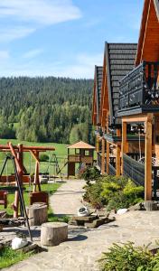 a building with a playground in front of it at Domki u Jacka - Rodzinny Relaks w Górach, SPA i atrakcje dla dzieci in Ząb