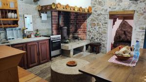 a kitchen with a wooden table and a stove at Moinho da Cruz in Ponte de Lima