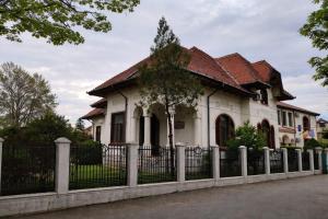 a white house with a fence in front of it at Vintage House Apart in Buzău