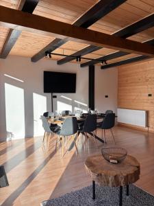a dining room with a table and chairs and a tv at The Black Barn in Frumosu