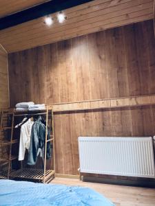 a bedroom with a wooden wall with a bunk bed at The Black Barn in Frumosu