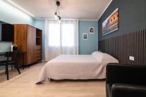 a bedroom with a bed and a chair and a desk at Casa Di Luca in Chioggia