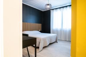 a bedroom with a bed and a desk and a window at Casa Di Luca in Chioggia