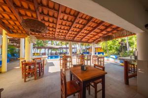 a restaurant with a wooden table and chairs on a patio at Hotel Meson de Mita in Punta Mita