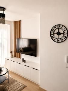 a white living room with a large clock on the wall at Veles in Banja Koviljača