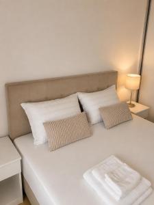 a white bed with two pillows on it at Veles in Banja Koviljača